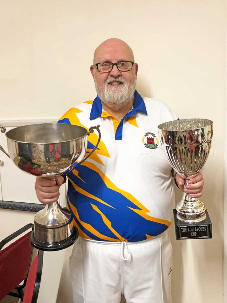 Club manager Bob Hayter holding a pair of large trophies